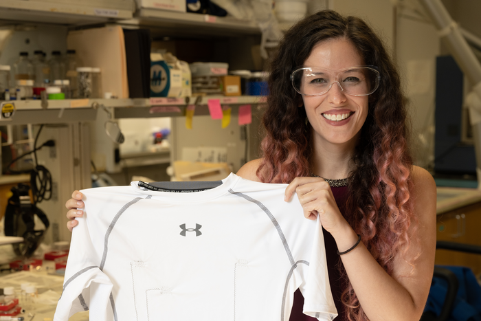 Rice University graduate student Lauren Taylor shows a shirt with carbon nanotube thread that provides constant monitoring of the wearer’s heart. CREDIT Jeff Fitlow/Rice University